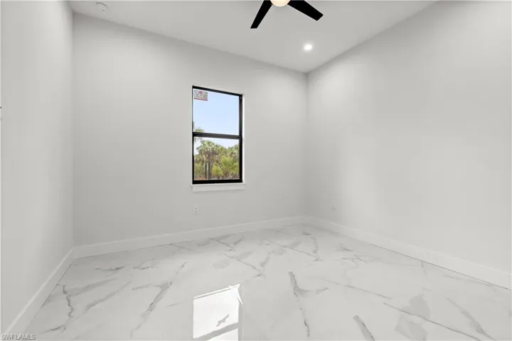 Spare room with ceiling fan, marble finish floors, and recessed lighting
