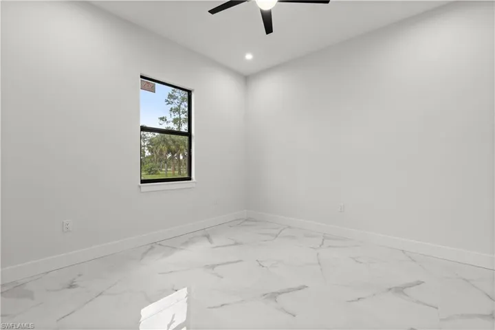 Spare room with light marble finish floors, a ceiling fan, and recessed lighting
