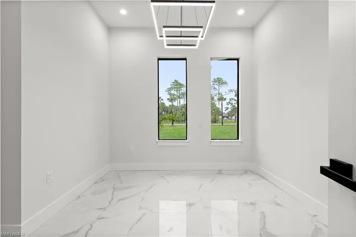 Spare room featuring marble look tiles and recessed lighting