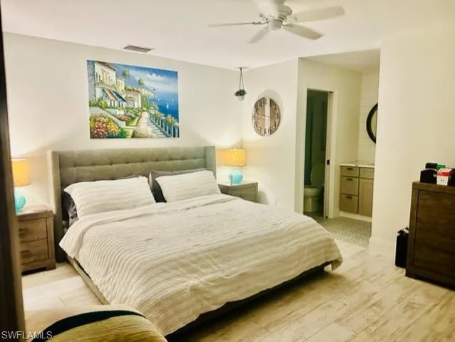 Bedroom with light hardwood / wood-style floors, ensuite bathroom, and ceiling fan