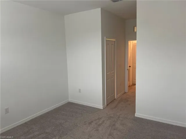 Unfurnished room featuring carpet floors and baseboards