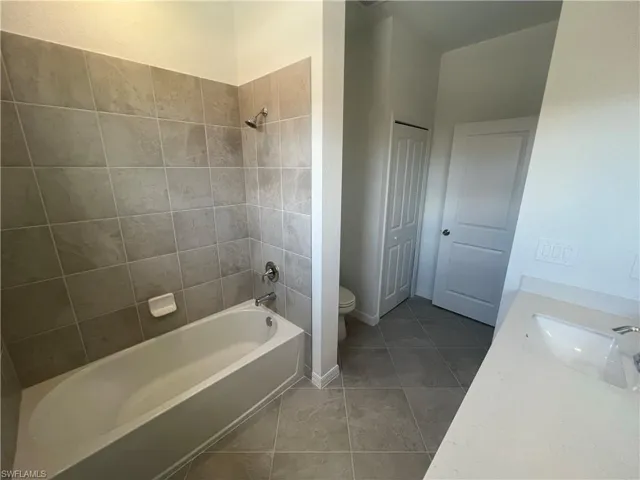 Full bath featuring vanity,  shower combination, and light tile patterned floors