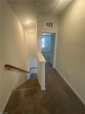 Staircase featuring carpet and baseboards