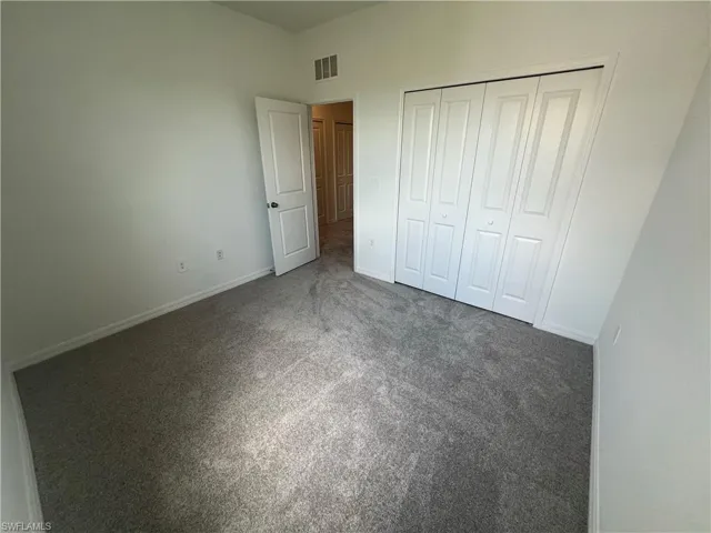 Unfurnished bedroom with a closet and carpet floors