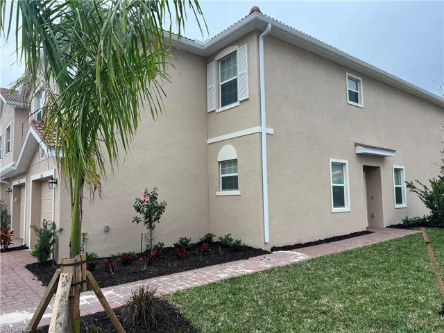 View of property exterior with a yard and stucco siding