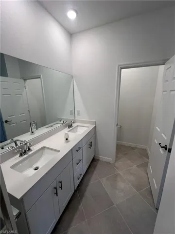 Bathroom featuring double vanity and light tile patterned floors
