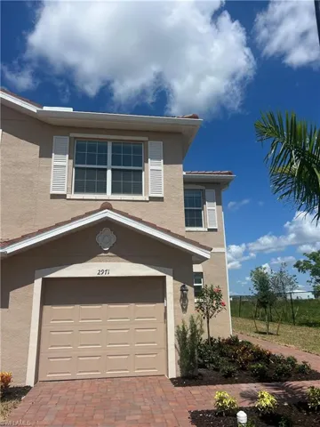 View of front of property featuring stucco siding, an attached garage, and decorative driveway