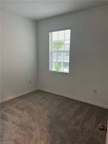 Unfurnished room featuring carpet and baseboards
