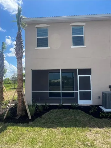 Rear view of house with a yard and stucco siding