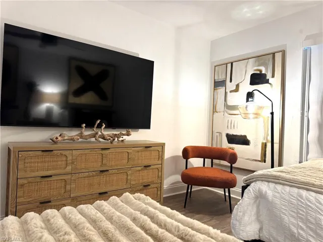 Bedroom featuring dark wood-style flooring and baseboards