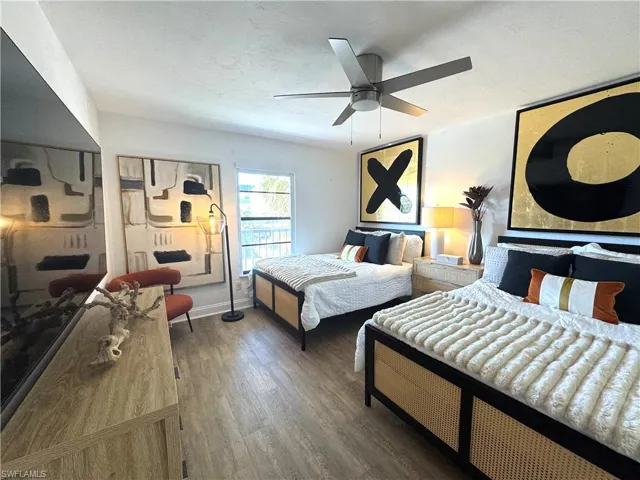 Bedroom featuring ceiling fan, a textured ceiling, baseboards, and wood finished floors