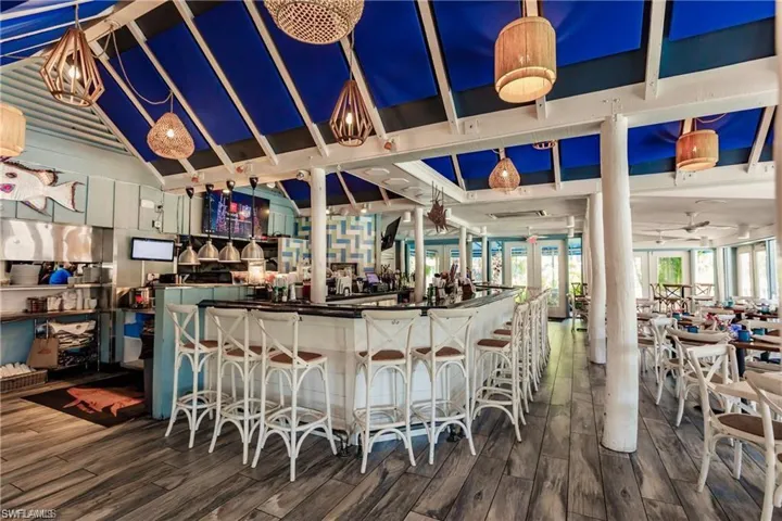 Bar with a dry bar and wood finished floors