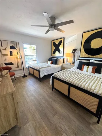 Bedroom featuring ceiling fan, dark wood-type flooring, and baseboards