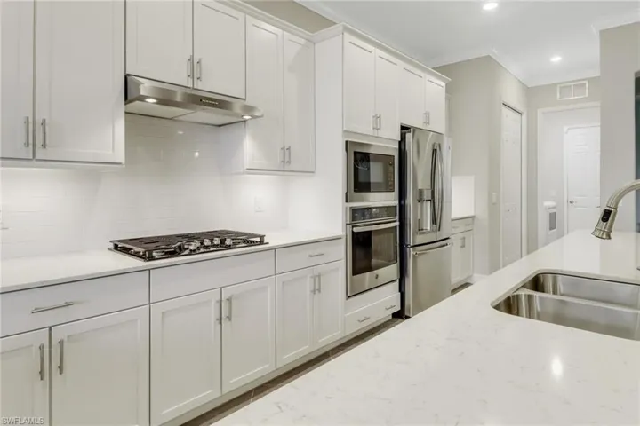 Kitchen with gas cooktop, upgraded white shaker cabinetry, stainless steel appliances & large pantry