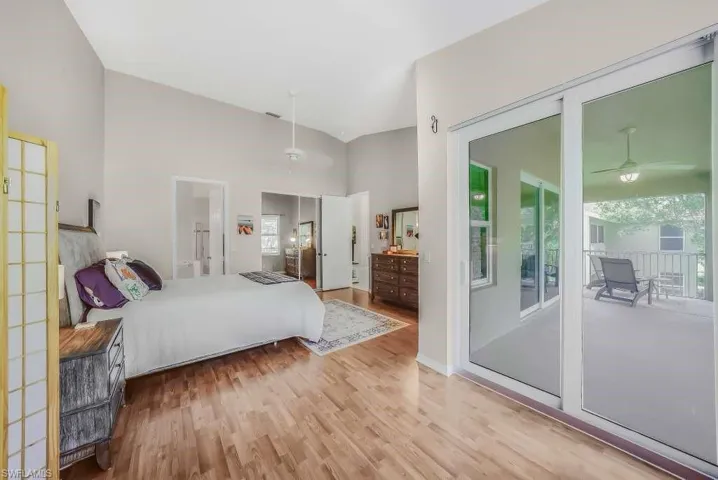 Bedroom with light wood-style floors, multiple windows, and access to outside