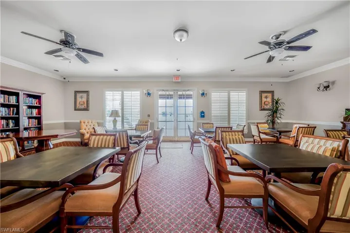 Dining area with ceiling fan, ornamental molding, french doors, and dark colored carpet
