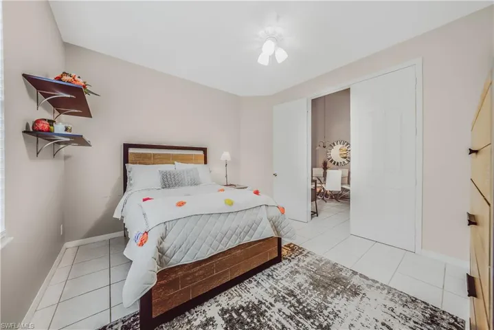 Bedroom with light tile patterned floors and a ceiling fan