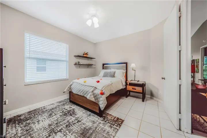 Bedroom featuring light tile patterned floors and baseboards