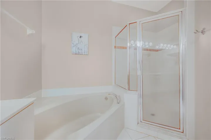 Full bath with a shower stall, tile patterned flooring, a garden tub, and vanity