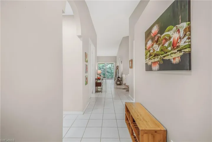 Corridor featuring light tile patterned floors and arched walkways