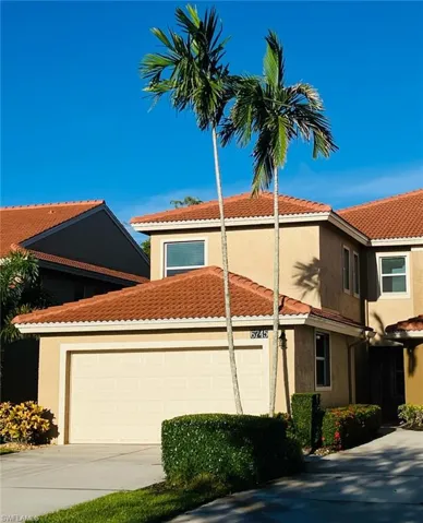 View of front of home with stucco siding, a tiled roof, a garage, and concrete driveway