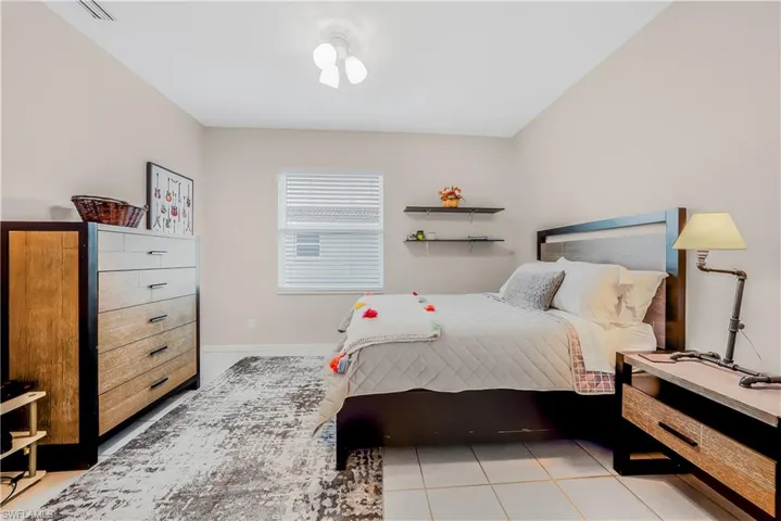 Bedroom with light tile patterned flooring and baseboards