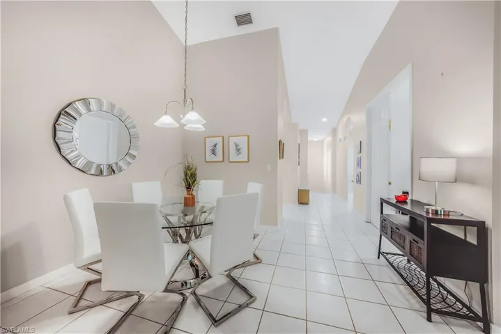 Dining space featuring light tile patterned floors, recessed lighting, and a chandelier