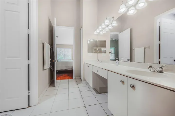 Bathroom with light tile patterned floors, double vanity, and ensuite bathroom