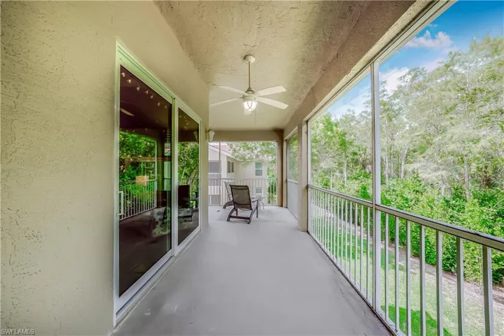 Balcony featuring ceiling fan and view of scattered trees