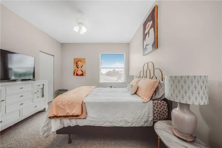 Carpeted bedroom with a ceiling fan