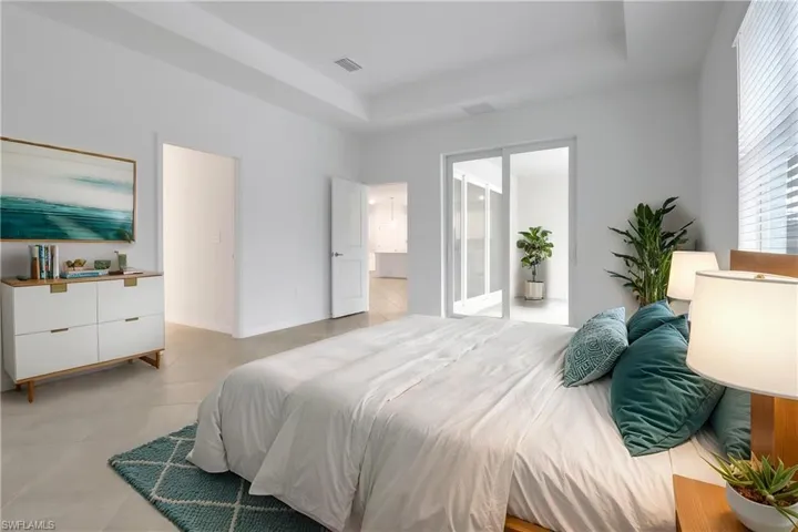 Bedroom with a tray ceiling, visible vents, and light tile patterned floors
