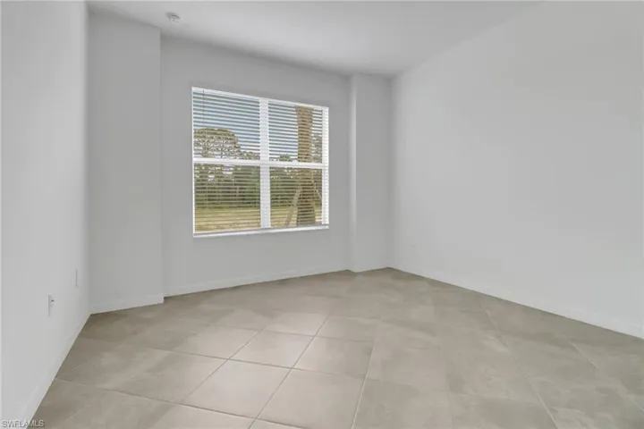 Empty room with baseboards and light tile patterned floors