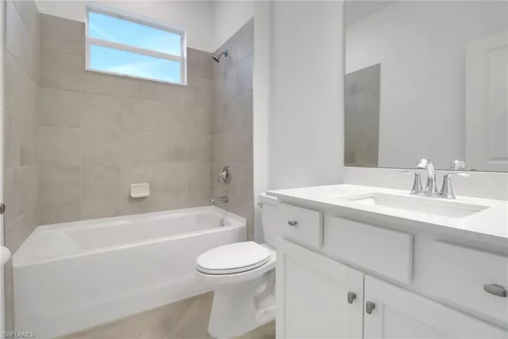 Bathroom featuring toilet, tile patterned floors, vanity, and bathing tub / shower combination