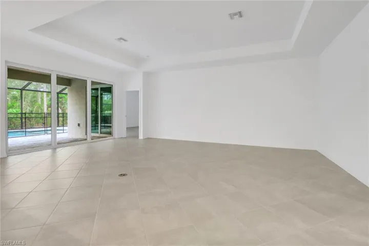 Spare room with visible vents, a raised ceiling, and light tile patterned flooring