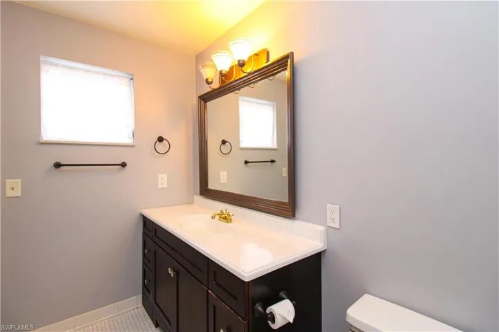Bathroom featuring vanity, toilet, and tile patterned flooring