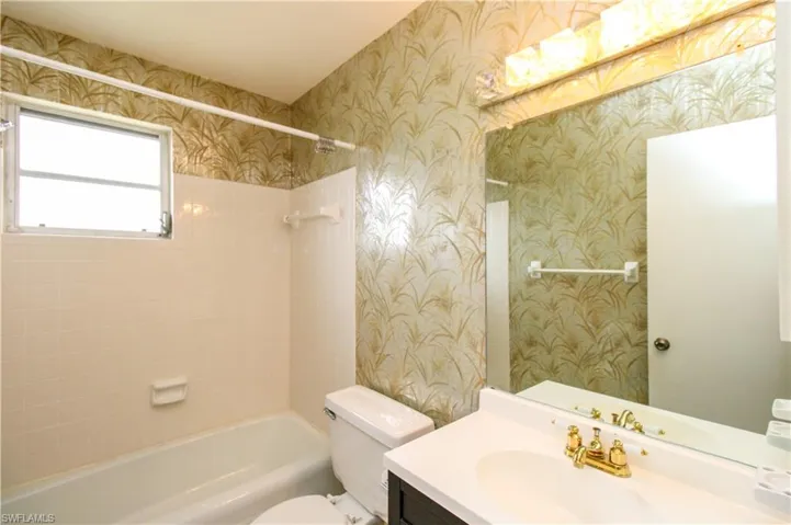 Full bathroom featuring vanity, tiled shower / bath, and toilet