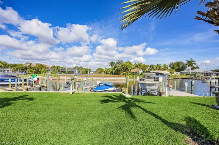 Dock featuring a lawn, a water view, and boat lift