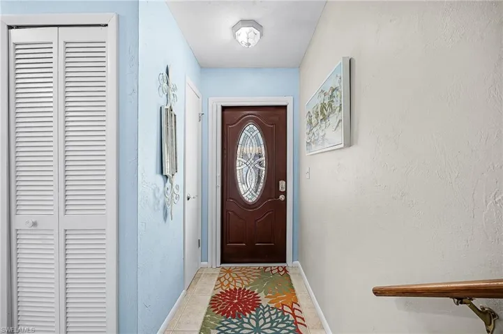 Entryway with a textured wall and tile patterned floors