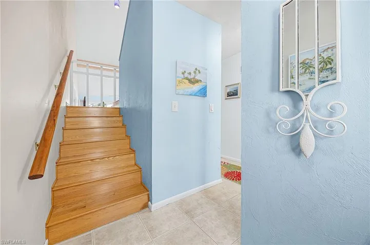 Stairway featuring tile patterned floors and baseboards