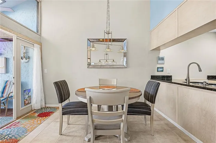 Dining room featuring light tile patterned floors and a towering ceiling