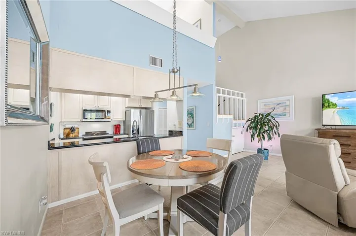 Dining room featuring beamed ceiling, high vaulted ceiling, and light tile patterned floors