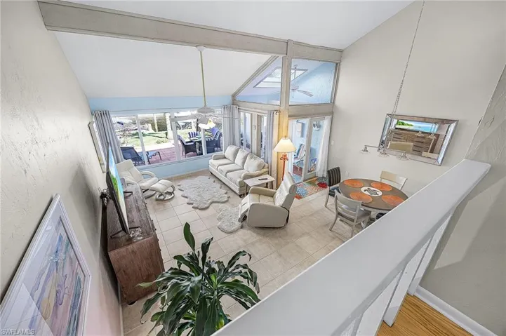 Living area with baseboards and high vaulted ceiling