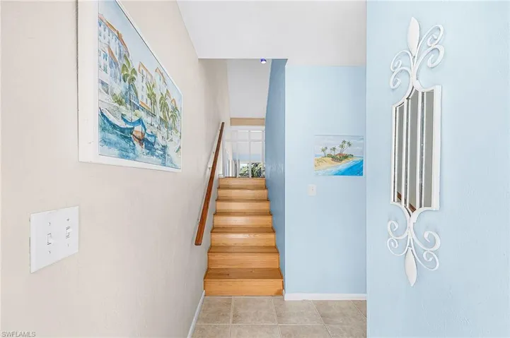 Staircase with tile patterned floors and baseboards