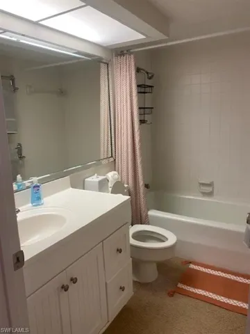 Full bathroom featuring shower / tub combo with curtain and vanity