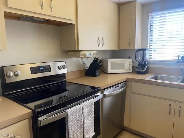Kitchen with stainless steel appliances and light countertops