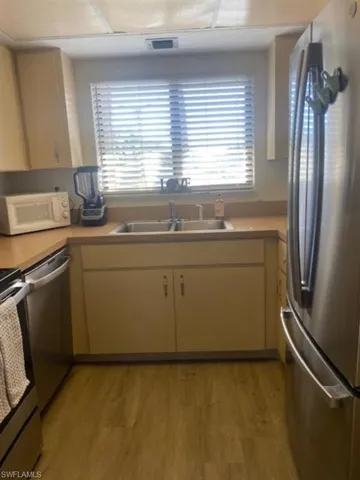 Kitchen with appliances with stainless steel finishes, light countertops, and light wood finished floors