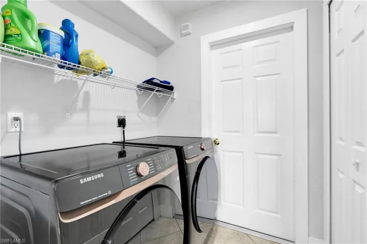 Laundry area with washing machine and dryer, laundry area, and tile patterned flooring