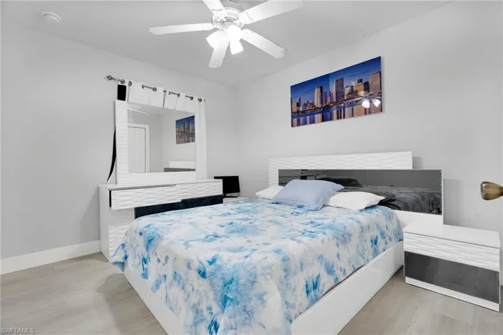 Bedroom with baseboards, wood finished floors, and a ceiling fan