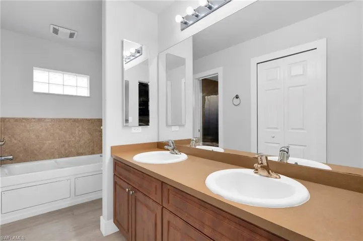 Full bathroom featuring a bath, visible vents, and a sink
