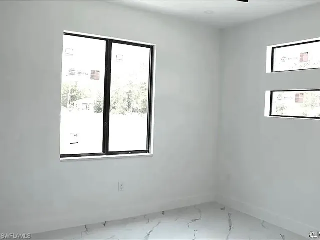 Bright interior space featuring a large picture window and two horizontal accent windows